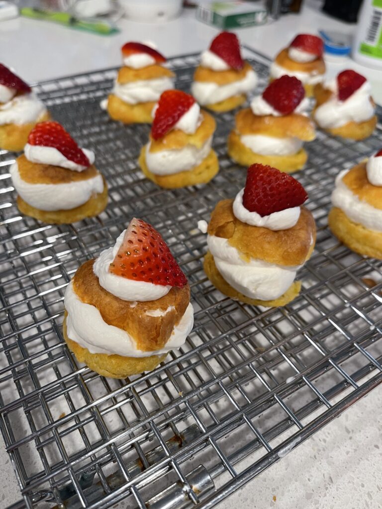 Homemade cream puffs topped with a piece of strawberry to celebrate St. Joseph's day with liturgicalliving